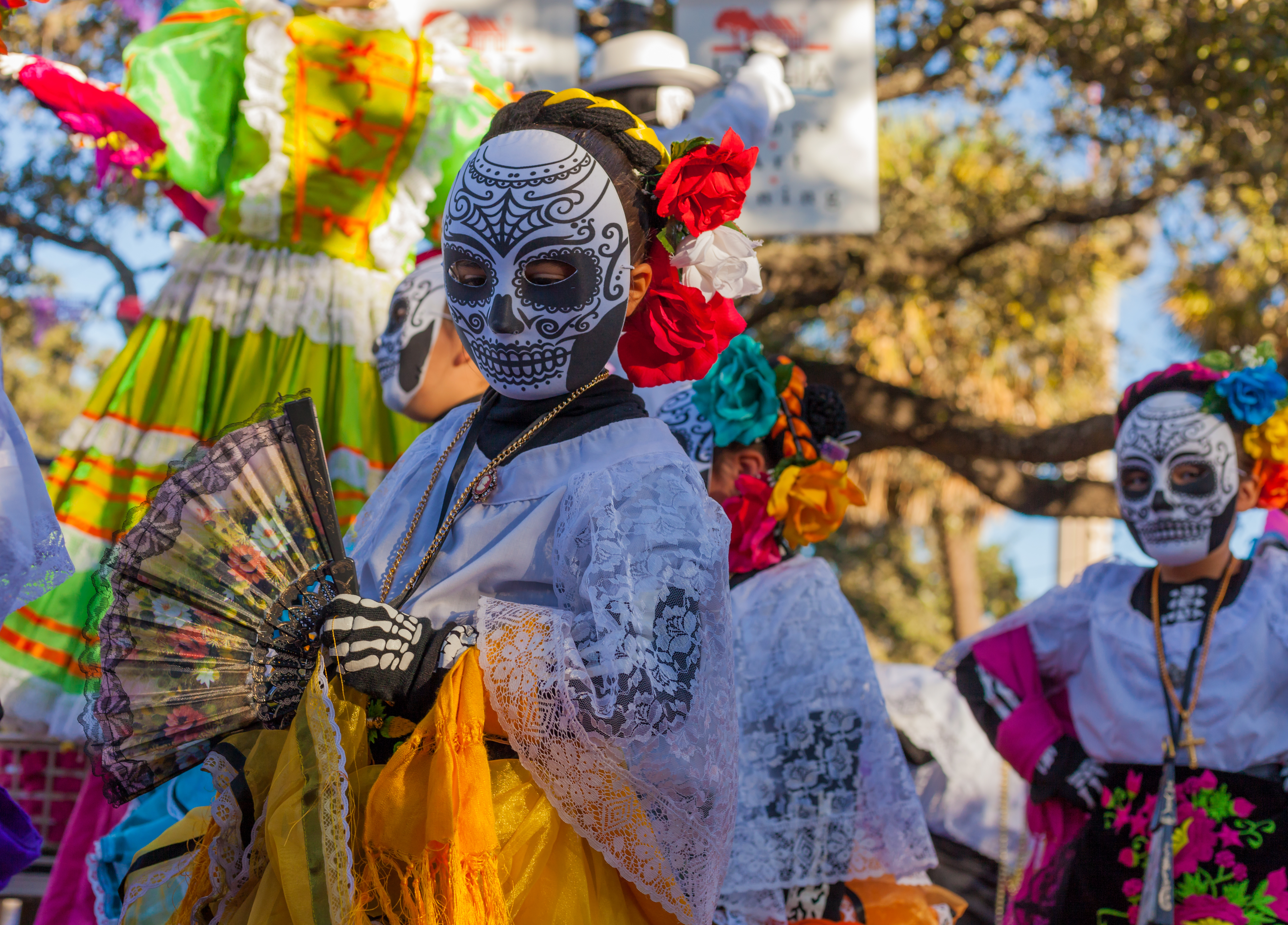 Vrouwen dragen maskers van traditionele suikerdoodshoofden